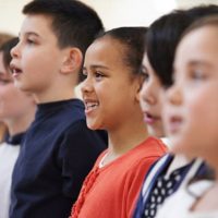Group Of School Children Singing In Choir Together
